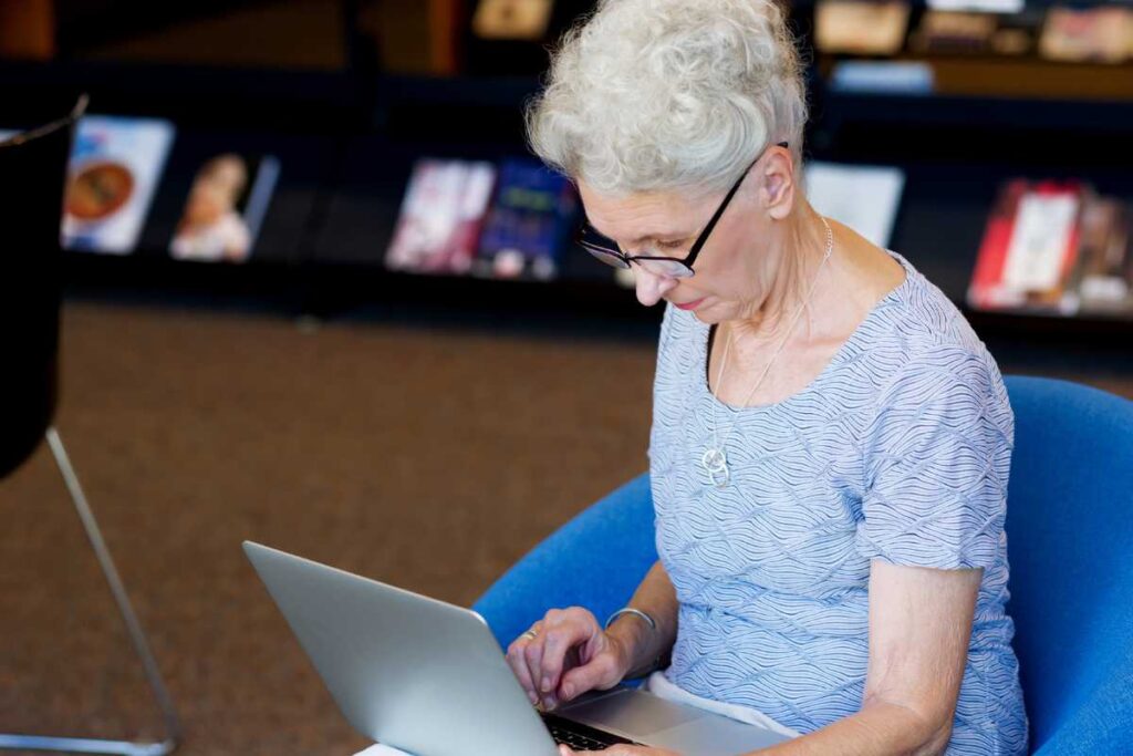 Senhora pesquisando no computador para Viajar de Forma Segura e Confortável na Terceira Idade