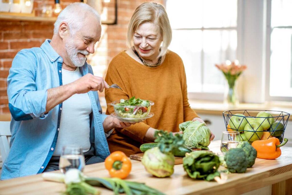 Casal de idoso preparando ingredientes para uma sopa nutritiva