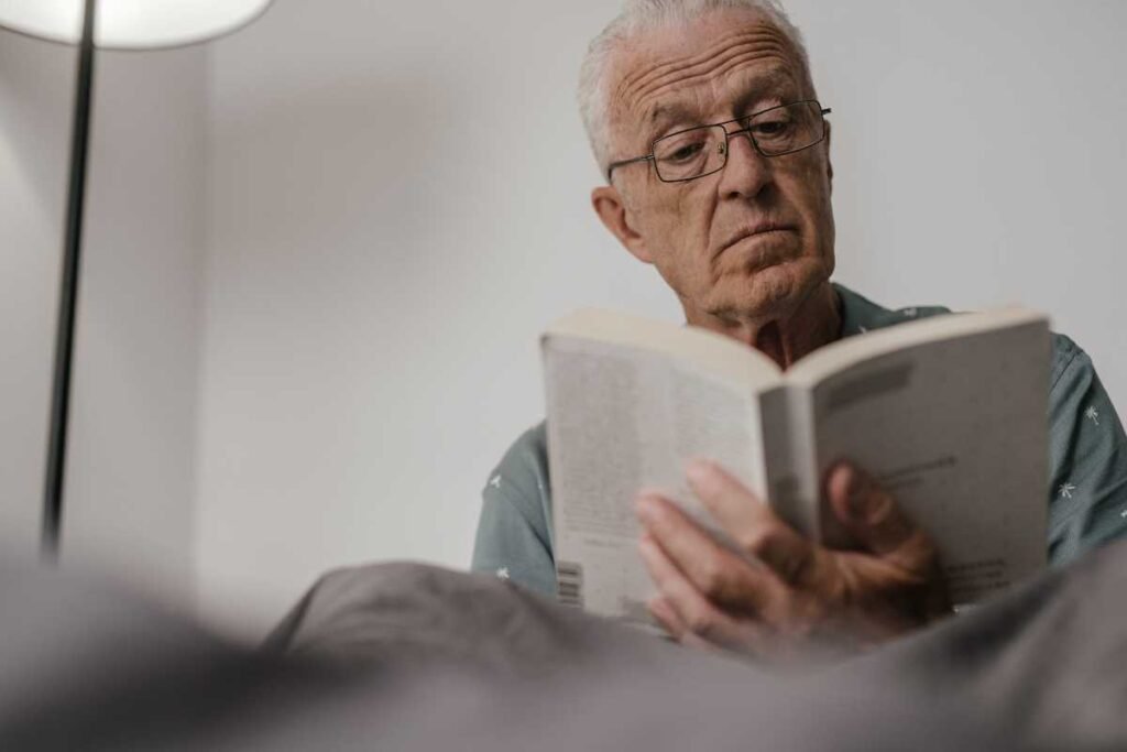 Senhor de óculos concentrado lendo.